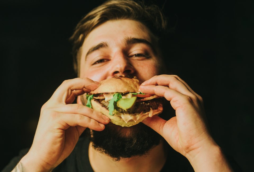 mężczyzna jedzący hamburgera